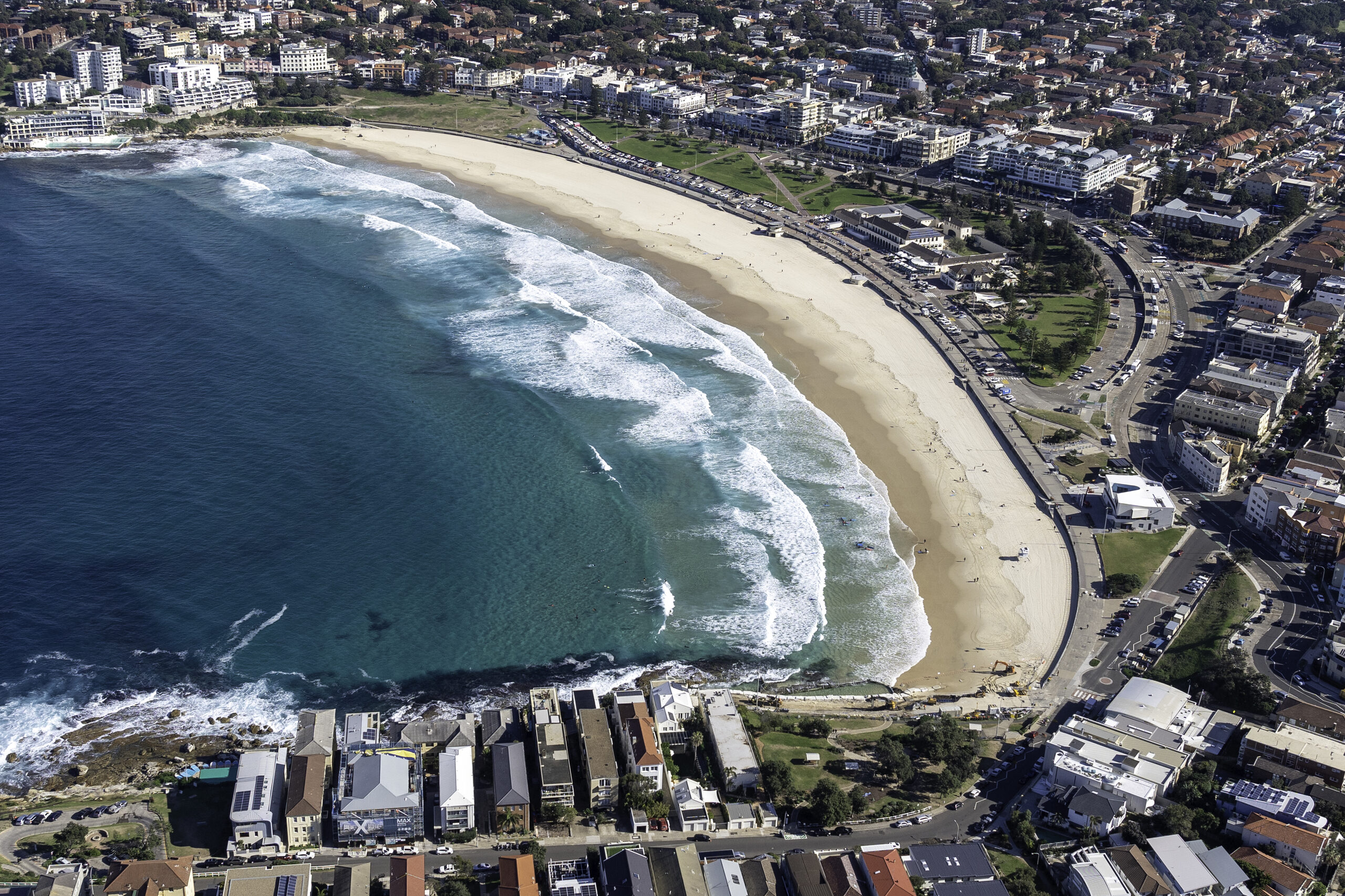 aerial view of Bondi Beach with waves breaking along the shoreline and the surrounding suburb